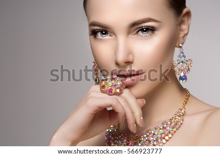 Beautiful woman in a necklace, earrings and ring. Model in jewelry from precious stones, diamonds.