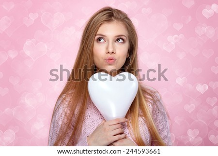 Valentines Day. Sweet blonde woman holding a balloon. heart shaped bokeh background Joyful