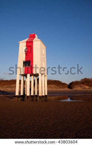 Wooden lighthouse built out of oak on the sandy beach at Burnham-on-Sea at sunset.