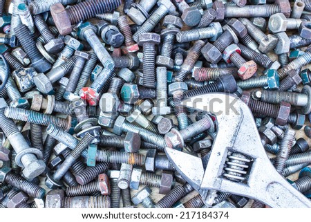 Spanner wrench and  screws on the wooden background