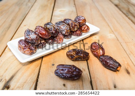 Dates fruit in a bowl closeup on wooden background