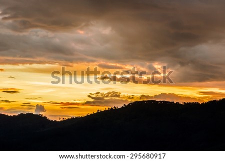 clouded orange sky with mountain silhouette