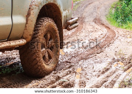 Wheel closeup in a countryside landscape with a muddy road