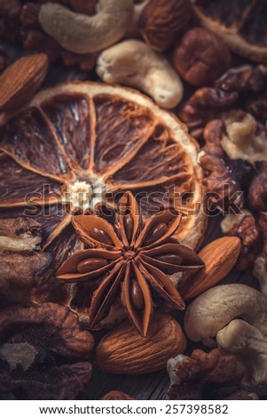 Herbs and spices with dramatic color grading. Focused on anise star.  Dried nuts, oranges and spices.