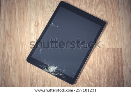 Black tablet computer with broken glass. Color graded picture.