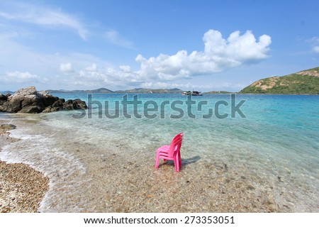 Pink chairs by the Crystal clear sea water with a beautiful blue sky and  mountain backdrop