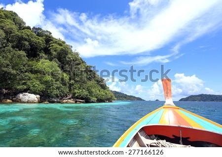 Long tail boats  with crystal clear water, mountains and bright blue sky  at Koh Lipe(Lipe island), Satun, Thailand