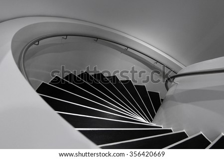 Spiral staircase in minimalism style. Black and white photo of contemporary architecture / modern interior design with soft shades of gray.