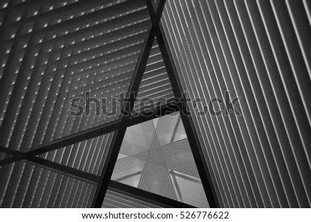 Pitched roof or ceiling. Reworked close-up photo of sloped walls. Realistic though unreal industrial interior. Abstract black and white background image on the subject of modern architecture.
