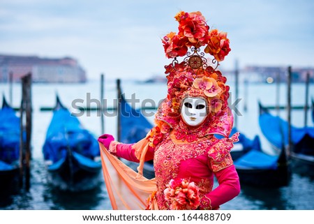 Venice, Italy - February 10: Unknown Woman In Red Dress Masked For Traditional Venice Carnival In Front Of Typical Gondola Boats, February 10, 2013 In Venice, Italy