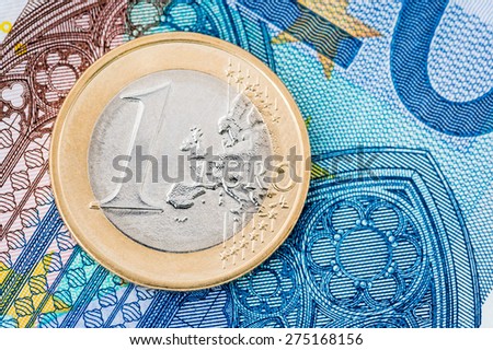 Detail of one Euro coin on blue banknote background