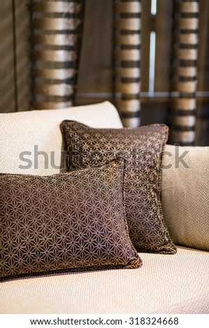 Detail of brown pillow on the beige sofa