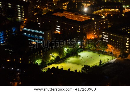 Aerial view of football pitch at night. Amateur football players. Football in the city.