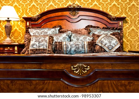 Classic bedroom detail with luxurious bed and stylish vintage decorated wall