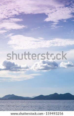 Mountains, sea and sky, the sky is cloud covered. Mountain complexes in a long line.
