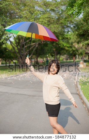 Women holding umbrella On the path in the park.