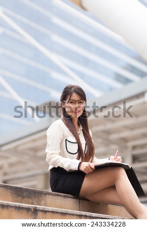 Smile and relax businesswoman.businesswoman writing paper and hold document file.sitting on sidewalk.