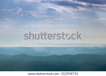 Forested mountains and sky. A slight mist-shrouded mountains and trees. Clear sky