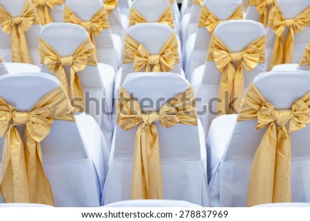 Indoor wedding. White cloth cover with a cloth and tied with a bow decorations.