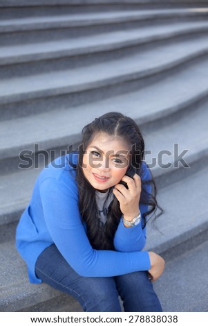 Woman sitting on the stairs. Woman with long hair sitting smile and feel good.