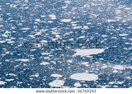 White sheets of ice in the deep blue ocean water