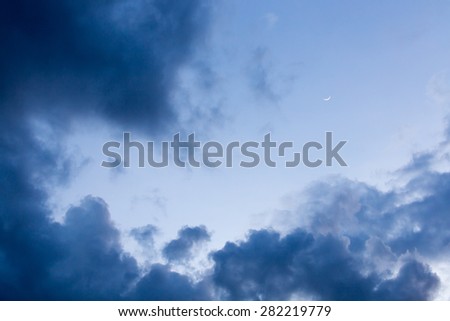 Stormy weather with dark clouds over blue sky at sunset