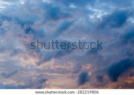 Stormy weather with dark clouds over blue sky at sunset