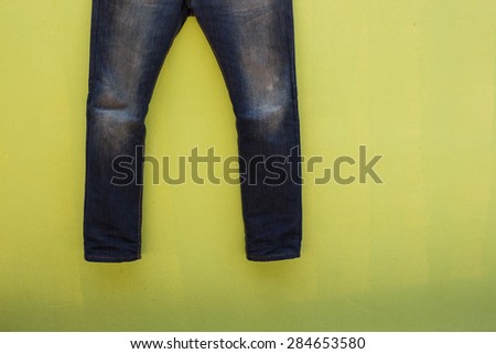 man jeans drying on green wall