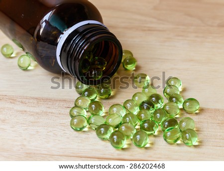 Supplement food,Vitamin E capsule on wooden table.