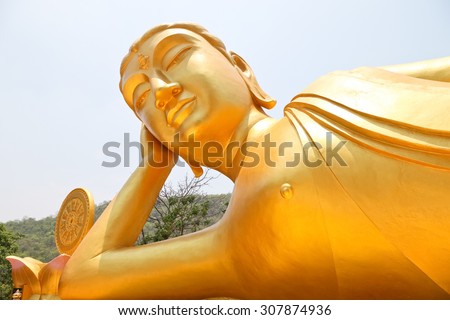 Reclining Buddha gold statue ,Reclining Buddha gold statue at temple Kanchanaburi, Thailand soft focus