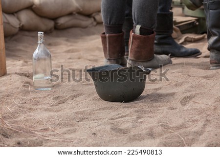 Old soldier helmet upside down on sand ground