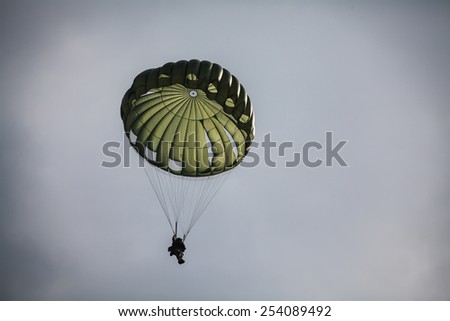 Military parachutist in the war cloudy sky