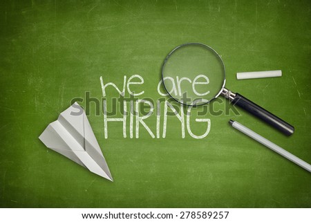 We are hiring concept on green full frame blackboard with magnifying glass