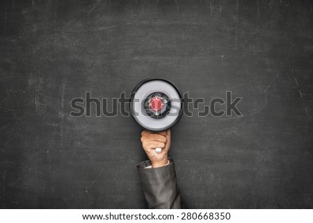 Businessman hand holding megaphone on front of vintage full frame black blank blackboard no frame