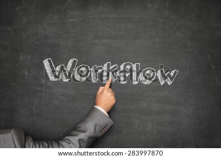 Workflow concept on black blackboard with businessman hand pointing