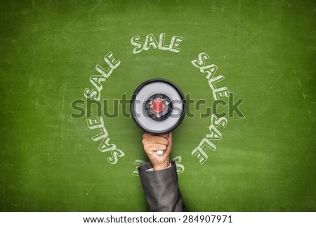 Sale text on blackboard and Businessman hand holding megaphone on front of vintage full frame black blank blackboard no frame