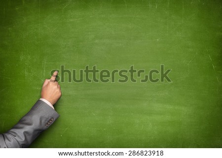 Blank green blackboard with businessman hand pointing