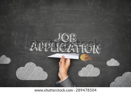 Job application concept on black blackboard with businessman hand holding paper plane