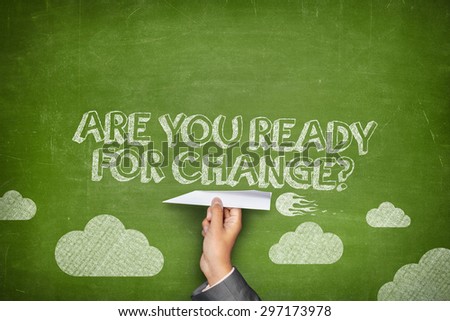 Are you ready for change concept on green blackboard with businessman hand holding paper plane