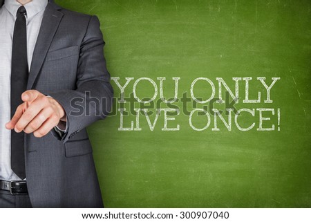 You only live once on blackboard with businessman finger pointing