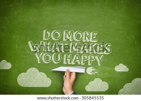 Do more of what makes you happy concept on green blackboard with businessman hand holding paper plane