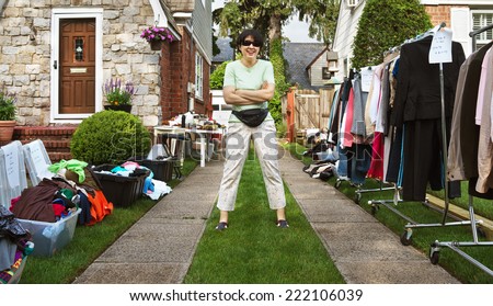 happy woman ready to sell items at yard sale.