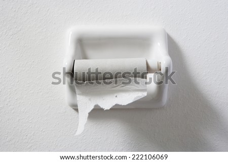 empty toilet paper roll on white wall