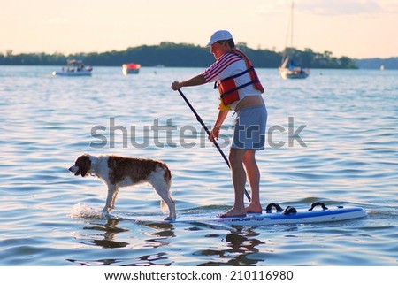 MADISON, WI - JULY 3rd, 2014: Candidate for Wisconsin Brett Hulsey campaigns at the University of Wisconsin\'s Memorial Union Terrace.  Paddle boarding with his dog Penny gathers lots of attention.
