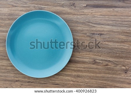 Top view of blue empty plate on wooden background with copy space