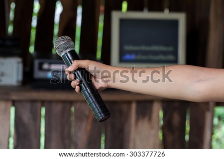 Old black microphone in hand, combined with the party.