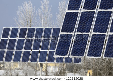 Solar Photovoltaic Panels In A Rural Residential Area Covered With Ice In Winter