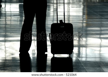 Silhouette Of A Traveler In An Airport With Their Carry On Luggage