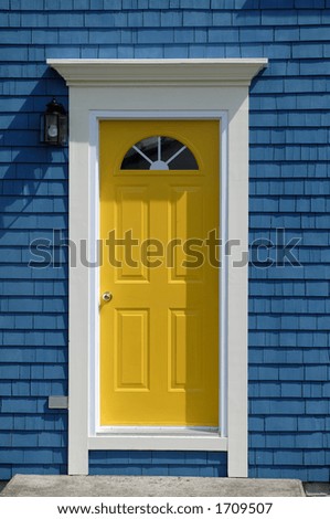 A Bright Yellow Front Door On An Old Traditional Cedar Shake House