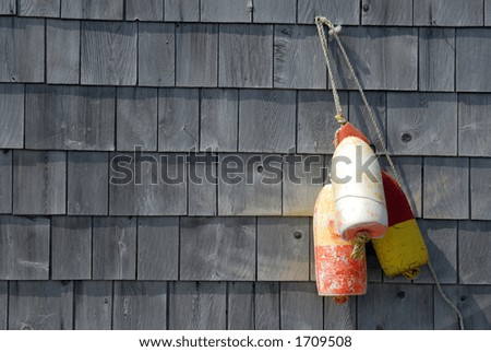 Old Fishing Buoy\'s Nailed To Shingled Wall